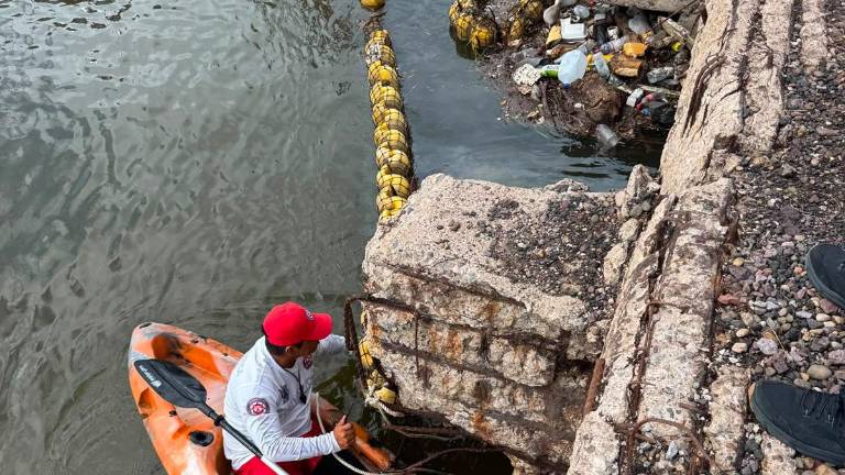 Personal del Escuadrón de Salvamento Acuático de Mazatlán ayuda a reparar la biobarda del Puente Juárez.