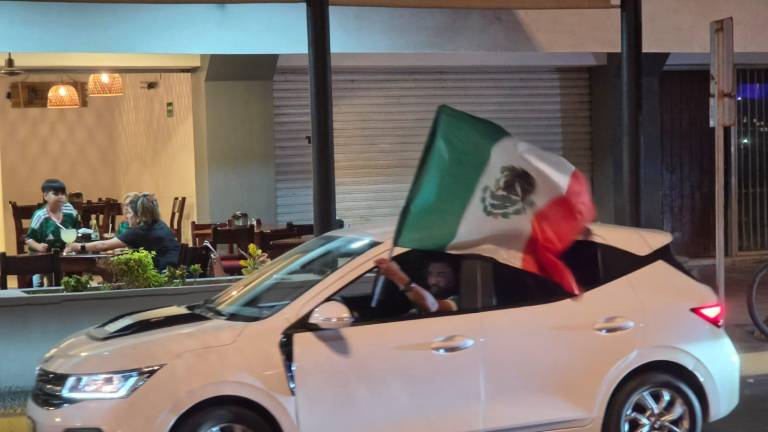 Los coches tocaron los claxon, mientras manos ondeaban la bandera de México.