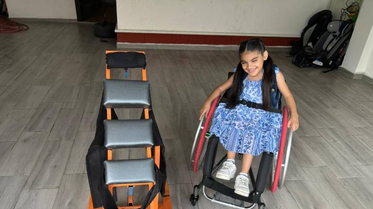 La silla de ruedas y el bipedestador ayudaron a Nicole cuando era más pequeña.