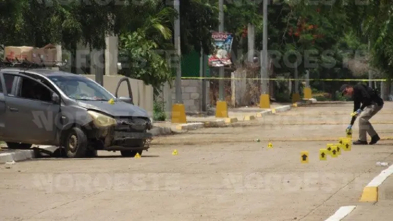 Autoridades inspeccionan el vehículo con impactos de bala localizado en la comunidad El Chilillo
