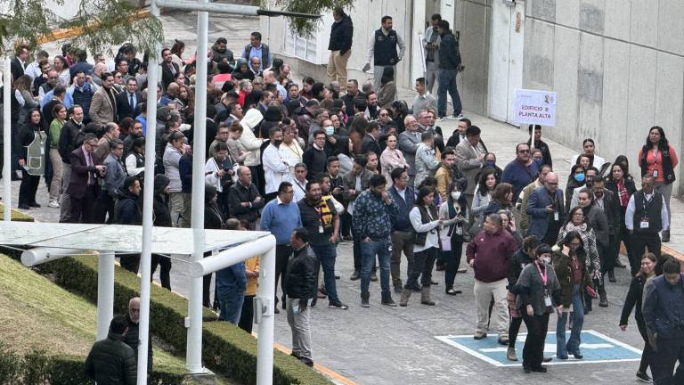Personal de la Secretaría de Seguridad y Protección Ciudadana desalojan el edificio tras activarse la alerta sísmica.