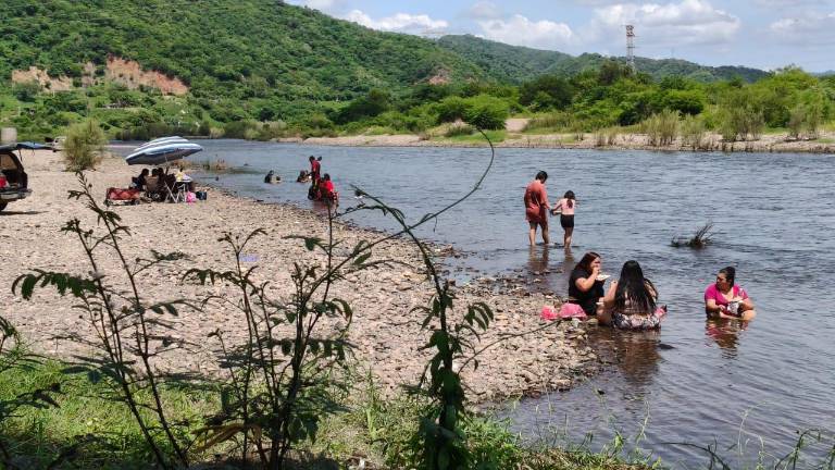 Las altas temperatura y la falta de energía eléctrica llevaron a familias a buscar un respiro en el río Baluarte.