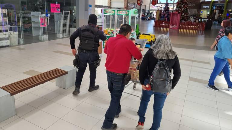 Policías acudieron a la plaza comercial en busca de recabar información para dar con el paradero de los asaltantes.