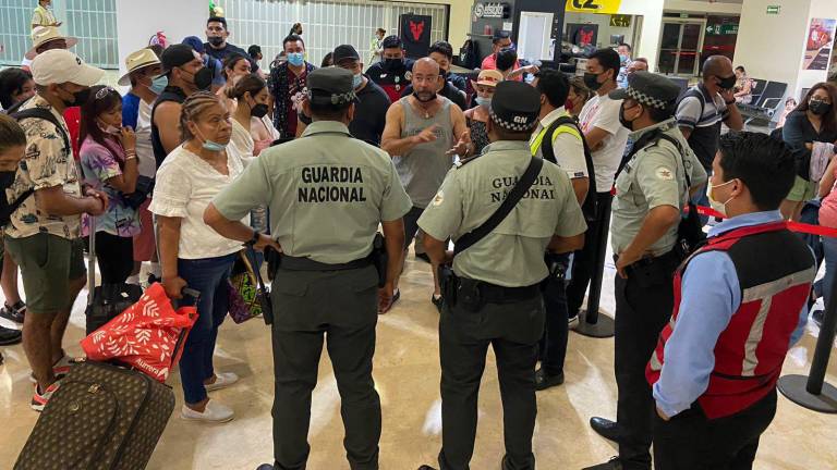 Pasajeros del vuelo cancelado de VivaAerobús encaran a personal del aeropuerto de Mazatlán.