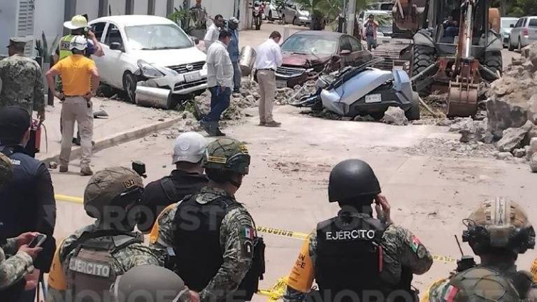 Vehículos dañaos a un costado del Faro de Mazatlán tras el desprendimiento de rocas.