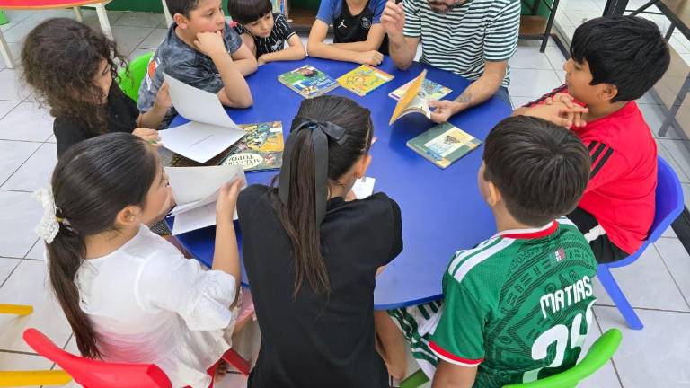 Niños y niñas disfrutan de la lectura.