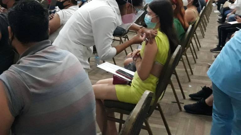 Una joven en el rango de 18 a 29 años recibe la primera dosis de Sinovac.