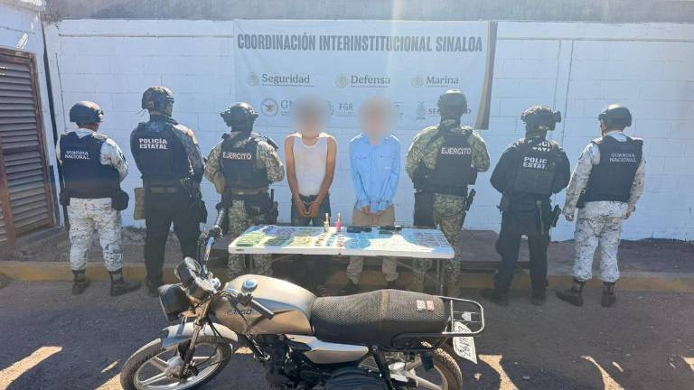 A los detenidos se les aseguró armas, presunta droga y una motocicleta en Culiacán.