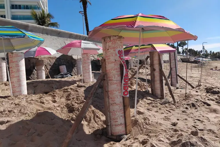 Sobre los pilotes de concreto de la obra suspendida, en la zona de playa de la Avenida del Mar, fueron colocadas sombrillas de colores.