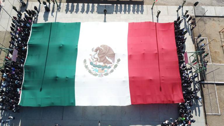 En ceremonia de Lunes Cívico en Jesús María, donde el 5 de enero fue detenido Ovidio Guzmán, fuerzas armadas extendieron una gran bandera de México.