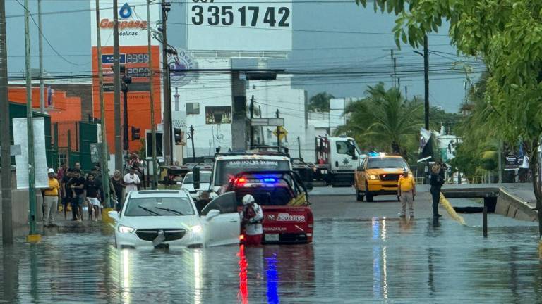 Auxilio a vehículos varados en vialidades que se inundaron en Mazatlán tras las lluvias.