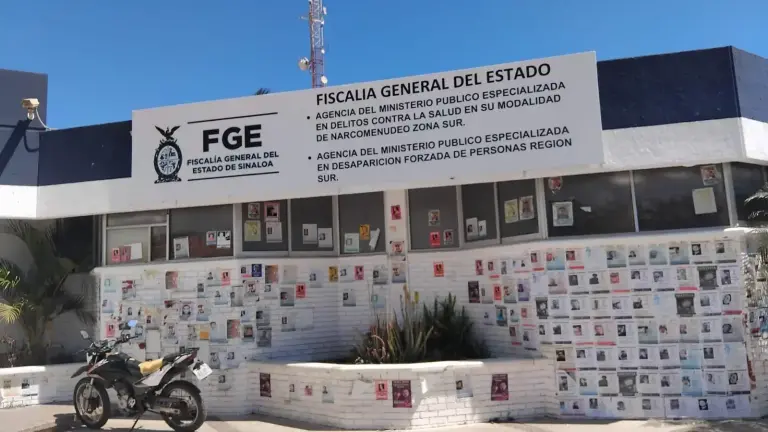 Fichas de búsqueda de personas desaparecidas pegadas en la fachada de la Fiscalía de Sinaloa en Mazatlán.