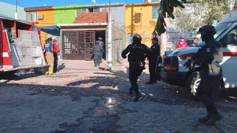 Bomberos y policías realizan operativo en la casa donde se prendió fuego.
