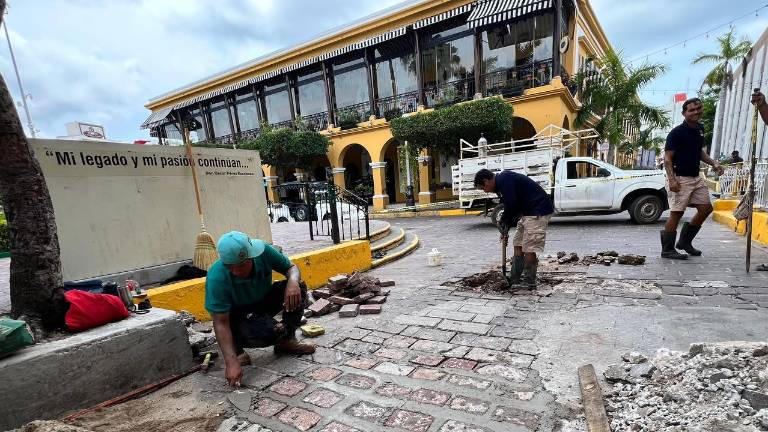 Trabajadores municipales realizaron labores para reparar desperfectos en la superficie de piedra pórfida en el Centro Histórico de Mazatlán.