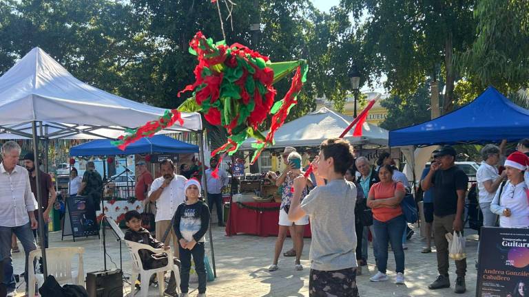 Niñas y niños participaron con entusiasmo en la tradicional piñata durante la posada navideña del Mercado Orgánico de Mazatlán.