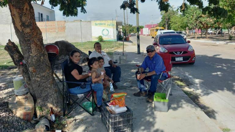 Ante los apagones por varias horas en el sur de Sinaloa, en Escuinapa las familias salen a comer debajo de los árboles.