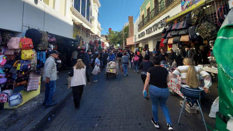 Decenas de personas transitan por las calles del Centro de Culiacán en busca de completar sus compras para la celebración navideña.