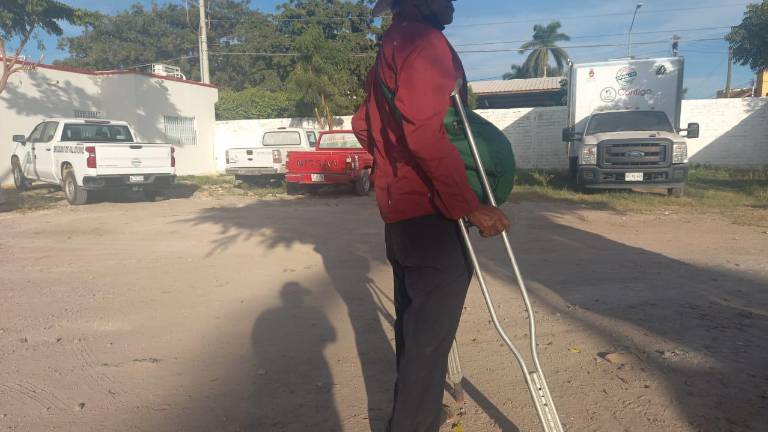 Don José se apoya con muletas para caminar.