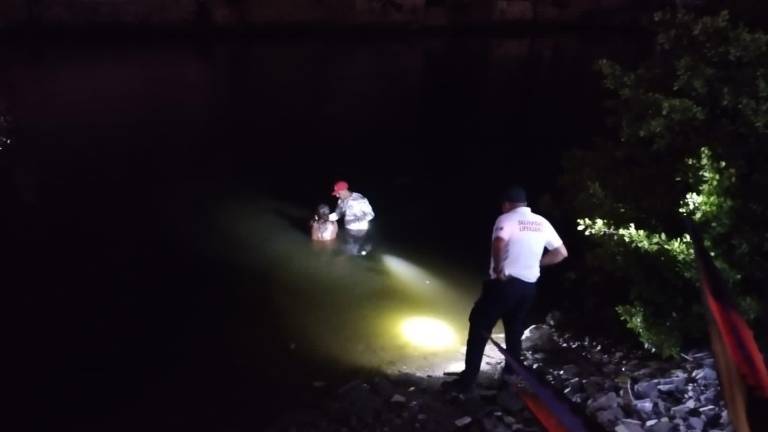 Policías rescatan a mujer de las aguas del Estero del Infiernillo.