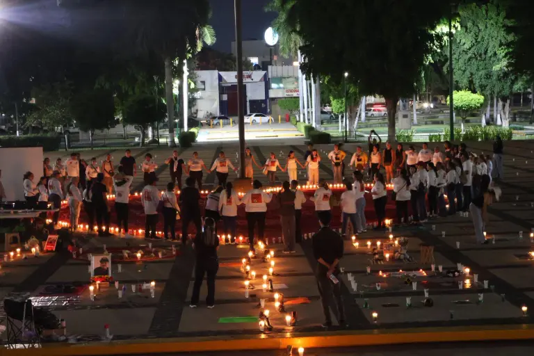 Familias de personas desaparecidas colocaron veladoras, fotografías y fichas de búsqueda durante una velada en Palacio de Gobierno, en Culiacán.