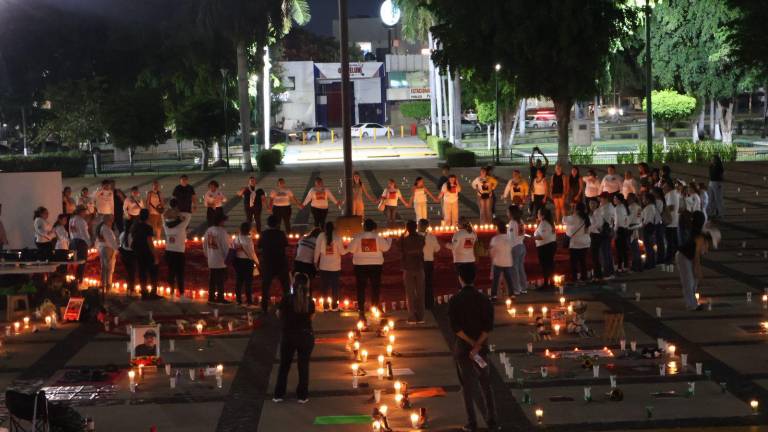 Familias de personas desaparecidas colocaron veladoras, fotografías y fichas de búsqueda durante una velada en Palacio de Gobierno, en Culiacán.