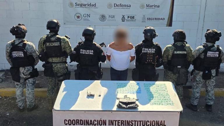La detenida fue presentada junto al arma y la droga aseguradas, bajo resguardo de policías estatales.