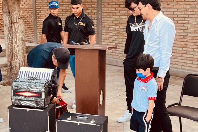 Los Dos Carnales le regalan acordeones a su primer maestro de música
