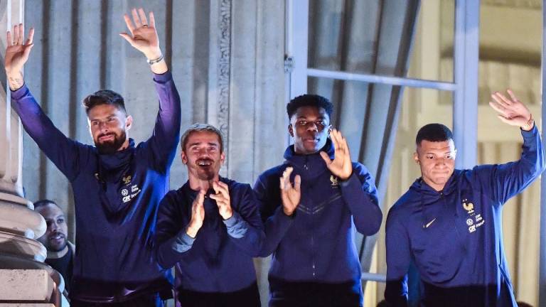 Los jugadores franceses, encabezados por Kylian Mbappé, saludan a los aficionados a su llegada a París.