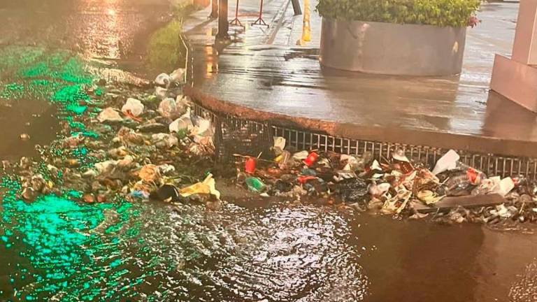 Alcantarilla pluvial bloqueada por la basura durante las lluvias en Culiacán.