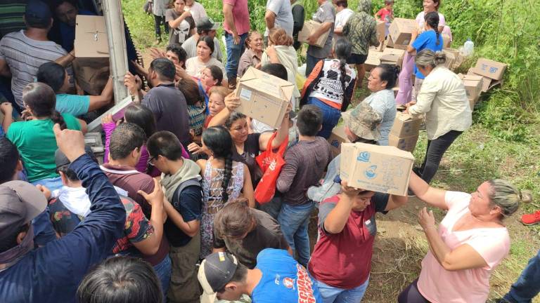 Los agentes de la Guardia Nacional nada pudieron hacer cuando los pobladores llegaron a robar las cajas de galletas.