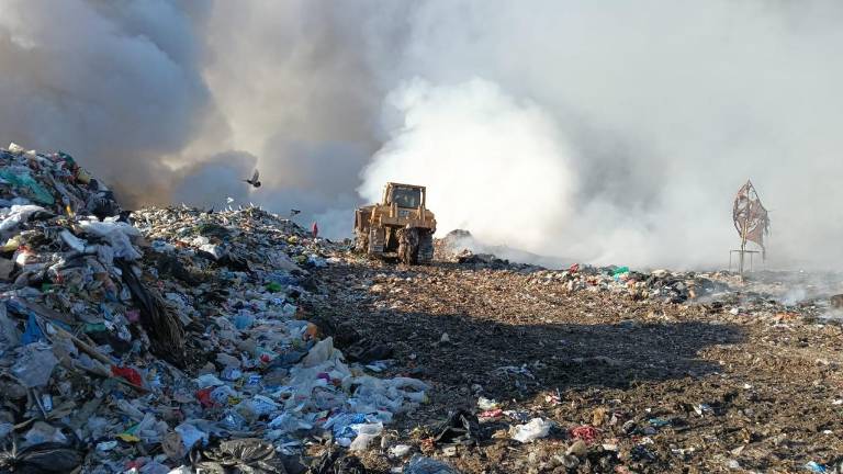 Cuerpos de rescate y maquinaria pesada trabajan en el control del incendio en el basurón municipal.
