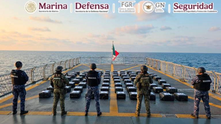 Personal de la Marina resguarda los 80 bultos con presunta droga asegurados frente a Guerrero.