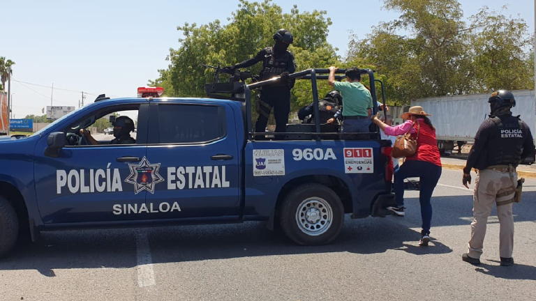 Policías estatales transportan a civiles que no han podido tomar el transporte debido a la manifestación.