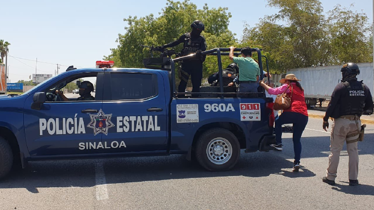 Policías estatales transportan a civiles que no han podido tomar el transporte debido a la manifestación.