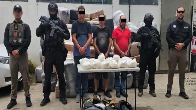 Elementos federales resguardan a los detenidos junto con la dorga asegurada.