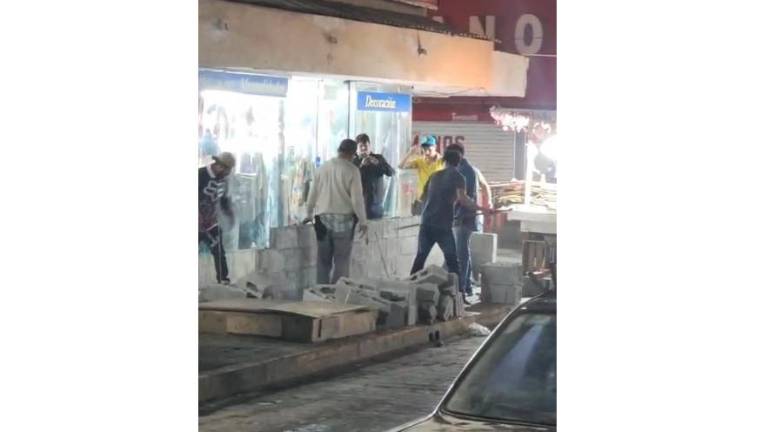 Con barra metálica en mano, los trabajadores derribaron la barda que había sido levantada sin permiso del INAH.