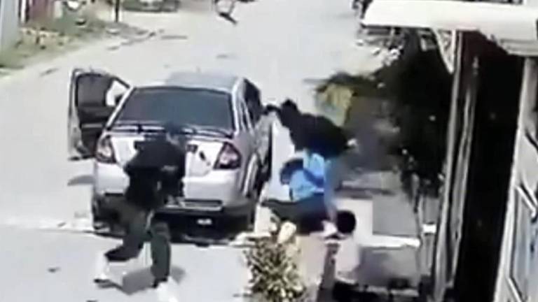 Cuando el vehículo arrancó, la mujer se aferró a una de las puertas y posteriormente cayó al pavimento, según un video del momento del ataque.