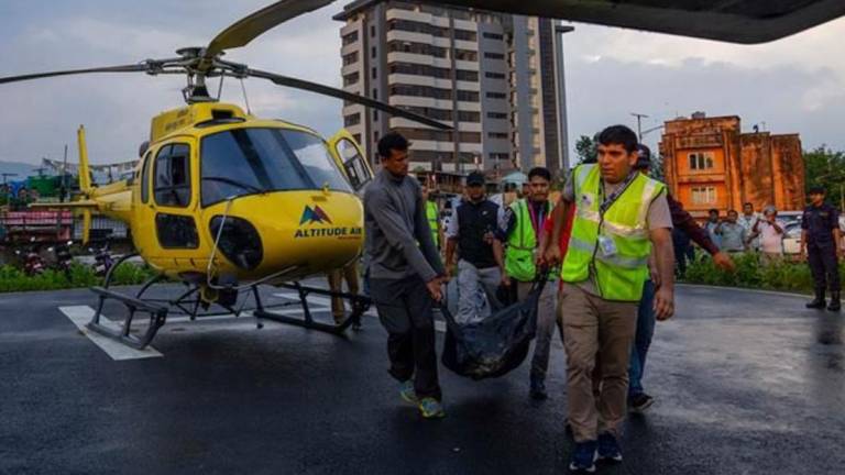Personal de emergencia traslada a las víctimas del accidente aéreo en Nepal.