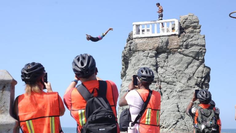 Turistas que llegaron a Mazatlán a bordo del crucero Discovery Princcess aprecian uno de los lanzamientos del clavadista.