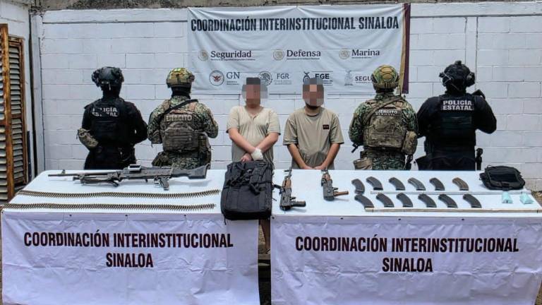 Autoridades resguardan a dos hombres detenidos en posesión de armas de alto poder y municiones.