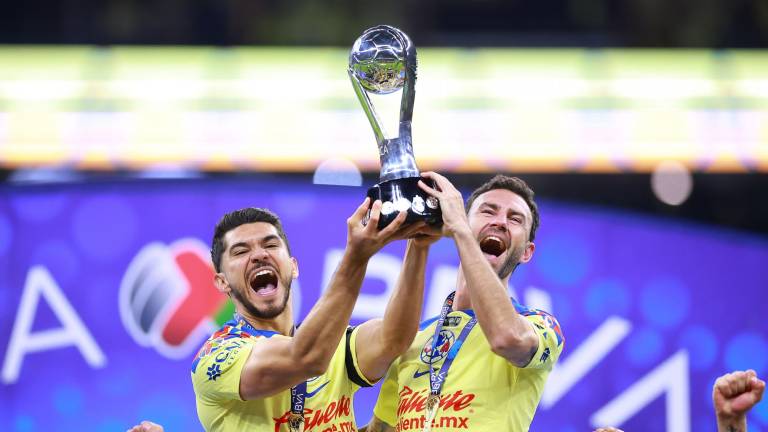 Henry Martín y Miguel Layún levantan el trofeo de campeones.