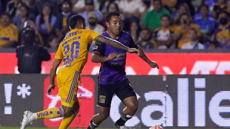 Marco Fabián busca realizar una jugada ante la marca de un jugador de Tigres de la UANL.