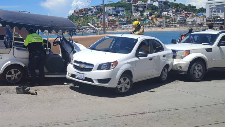 Un policía y un elemento de bomberos inspeccionan el accidente y a los heridos.