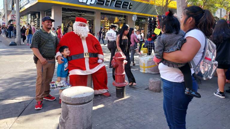 Familias se acercan a tomarse la foto del recuerdo con Santa Clos en las calles de Culiacán.