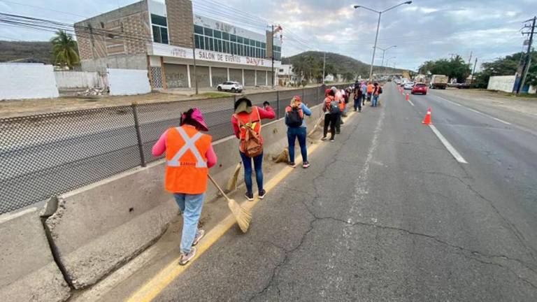 Una cuadrilla de trabajadores limpia la salida sur de Mazatlán.