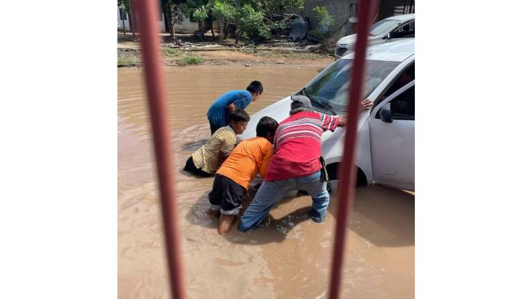 Vehículos quedan atascados en calles inundadas de Isla del Bosque.