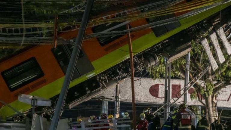 Trabajadores de emergencias junto a uno de los vagones de metro desplomados en Ciudad de México. En video, el momento del accidente.