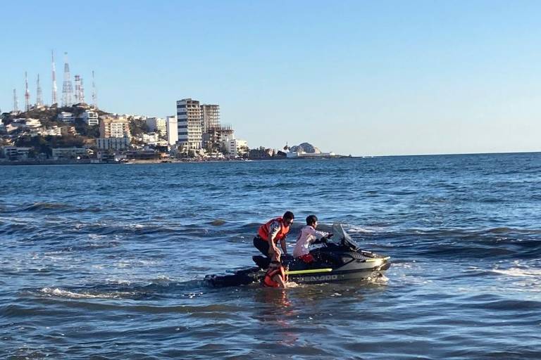 Cae al mar una pareja que viajaba en parachute; rescatan a 10 más que eran jalados por la resaca