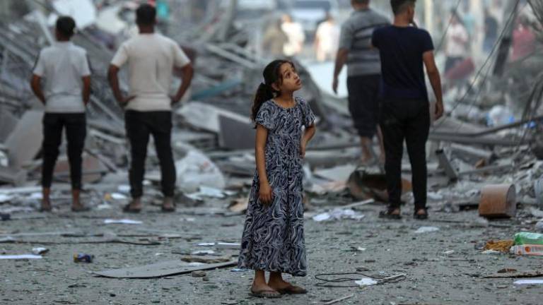 Amal, de 7 años, contempla su vecindario después de que las casas vecinas fueran arrasadas. No hay palabras que puedan describir la devastación que ve.