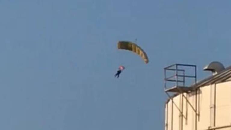 La mujer en descenso en el paracaídas.